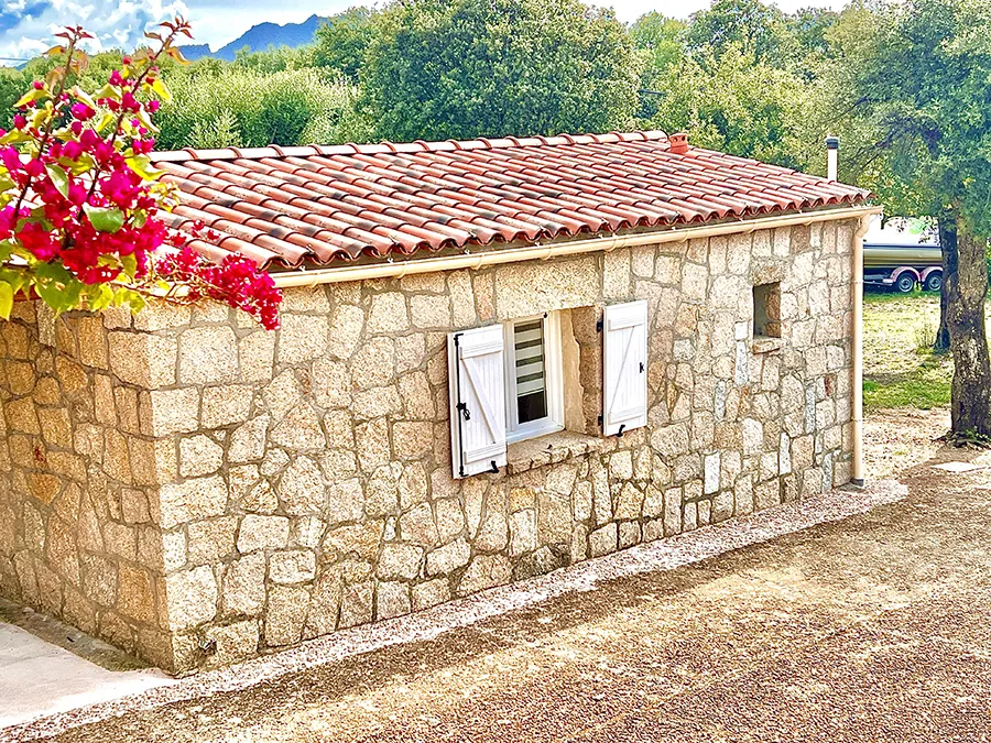 Vue d'ensemble de l'entrée principale de la villa Caseddu Jardin et Mer, avec jardin verdoyant, idéale pour séjour en Corse du Sud.