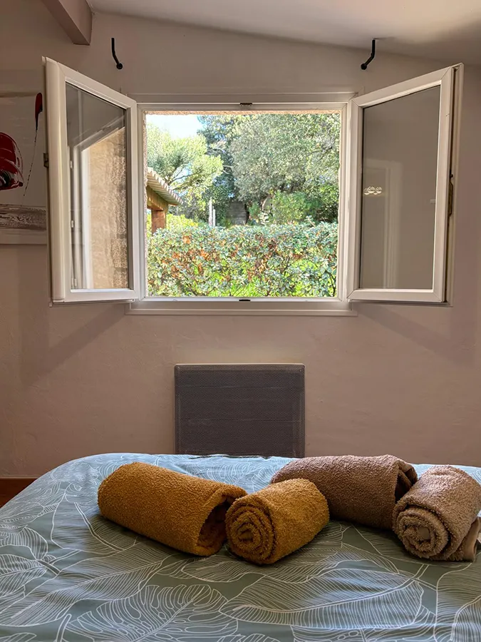 Chambre à coucher lumineuse et spacieuse de la villa Caseddu Jardin et Mer, avec lit double et accès terrasse, pour des nuits calmes en Corse du Sud.