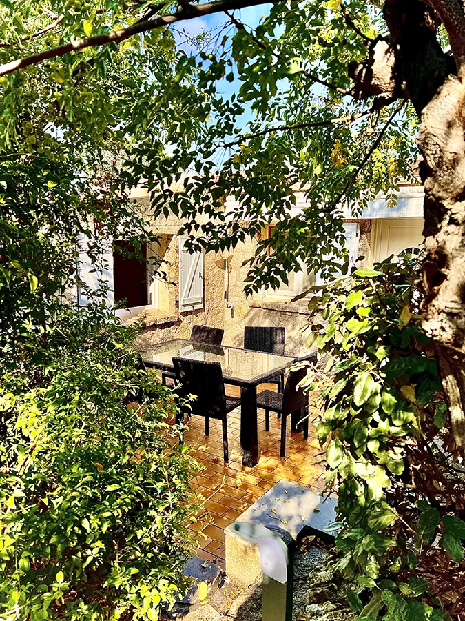 Allée de jardin aménagée et fleurie menant à la villa Caseddu Jardin et Mer, location pour vacances en Corse.