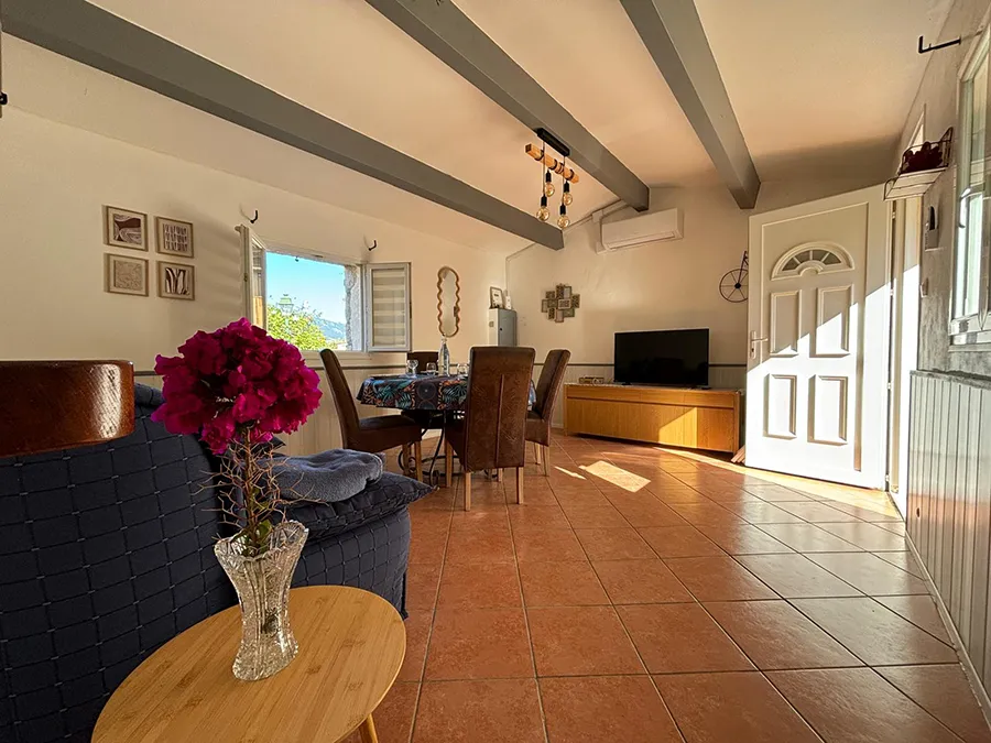 Salon spacieux et lumineux avec vue sur l'extérieur de la villa Caseddu Jardin et Mer, confortable pour des vacances en Corse du Sud.