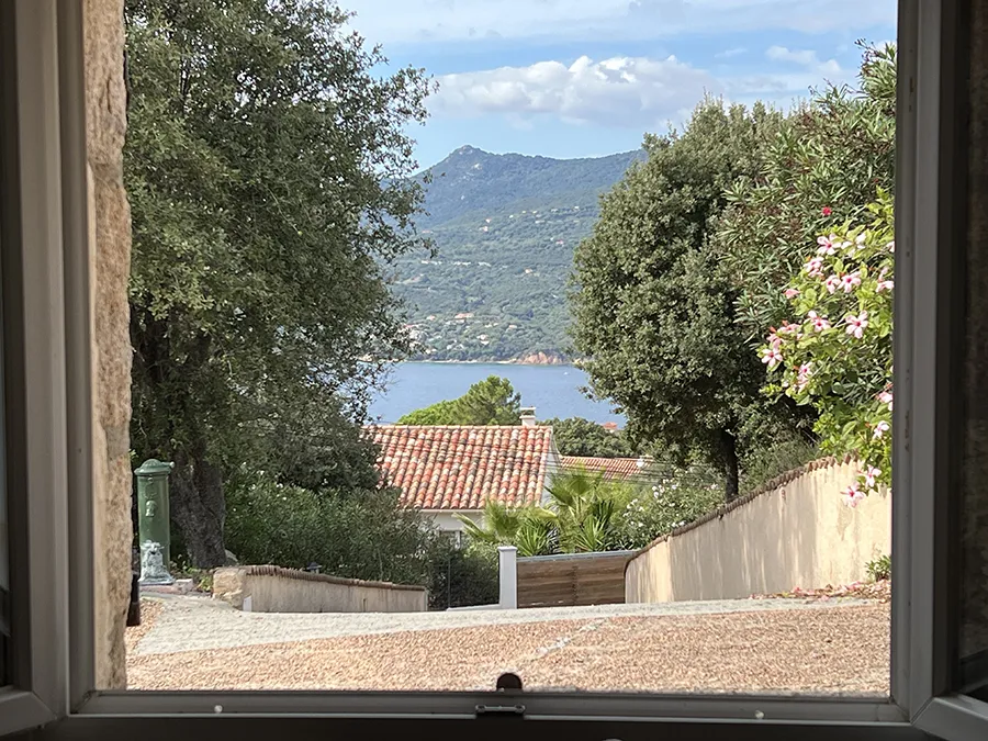 Vue sur la mer et les collines depuis la fenêtre de la villa Caseddu Jardin et Mer, location de vacances en Corse du Sud.